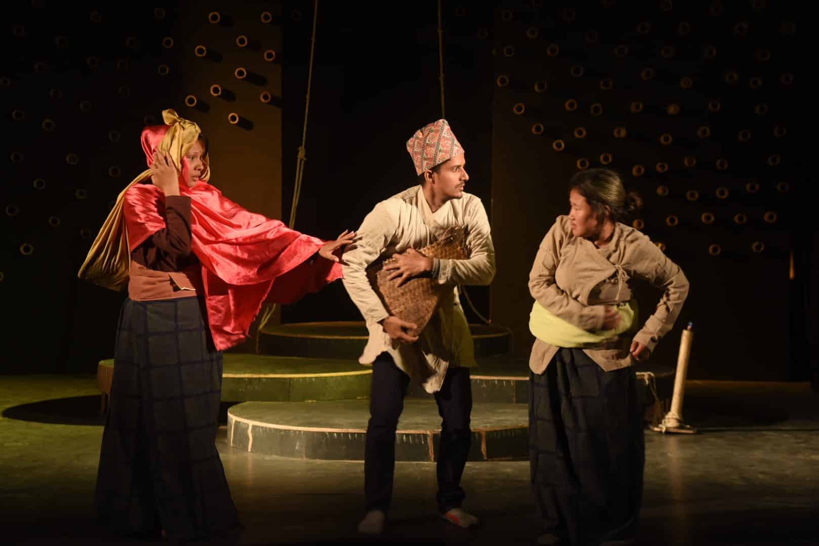 picture showing three people in the middle man is standing and side by side women are standing and acting